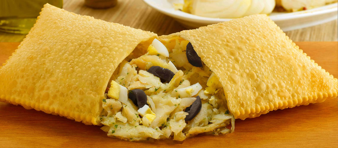 Pastéis fritos, um deles aberto mostrando o recheio